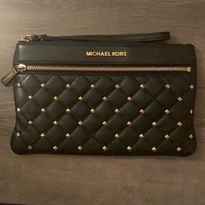 Black MICHAEL KORS wristlet. Gently used. Missing one gold piece at the bottom.
